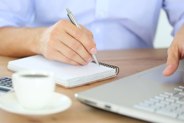 Male hand holding silver pen