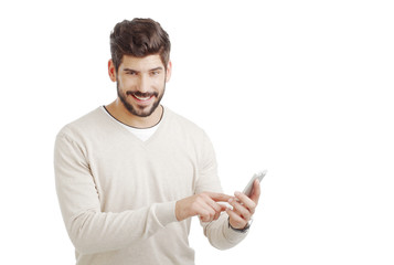 Portrait of casual businessman using private banking. Young professional standing against white background while holding hand mobile phone and touching the screen.