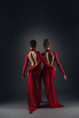 Rear view on elegant dancers in long lace dresses