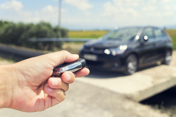 man opening his car with the control remote key, outdoors, filte