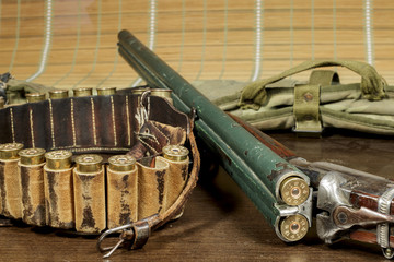 Old double-barreled shotgun beside a cartridge box