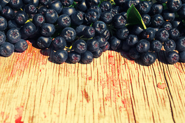 Black mountain ash against a textural old wooden surface. Black-fruited mountain ash - an autumn background