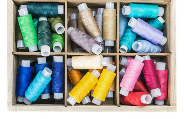 colored thread in the bobbin in a wooden in box
