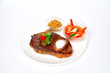 Grilled pork steak with croutons, salad, sauce and tomatoes.