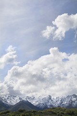 Vertical snow capped peak photo with sky 