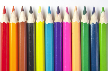 Line of colored pencils isolated on white background close up