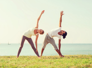 couple making yoga exercises outdoors