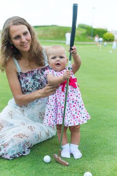 Mother and her little daughter practicing to hit the ball
