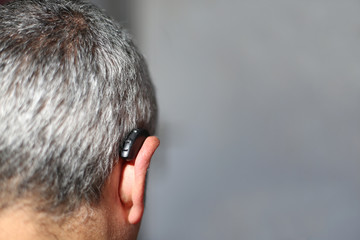 Grauhaariger Mann mit Hörgerät