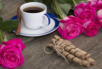 cup of coffee and from two parties red roses
