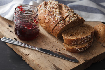 Dark multigrain bread whole grain and jam fresh baked on rustic
