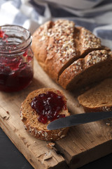 Dark multigrain bread whole grain and jam fresh baked on rustic