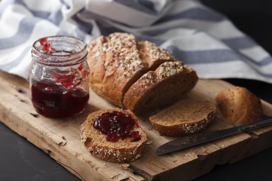 Dark multigrain bread whole grain and jam fresh baked on rustic