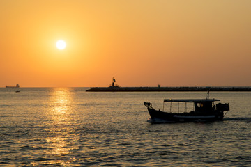 Passaggio di una barca nel porto sulla laguna durante l'alba