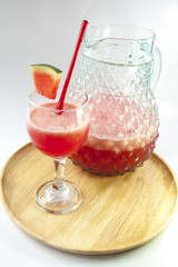 Watermelon juice in a glass on wood plate