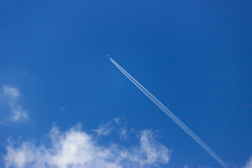 Белые облака и самолет на синем небе