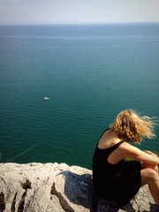 Blonde, lockige Frau an Klippen