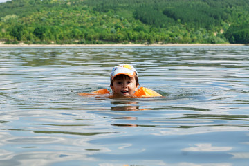 Boy learns to swim. Swimming float for kids