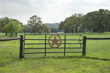 Ranch gate with pasture and trees in the Texas Hill Country