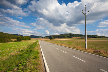 Fototapeta na wymiar On the empty road between field
