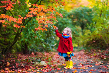 Little girl with yellow autumn leaf