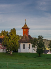 Fototapeta na wymiar Sunrise on a small chapel in the Swiss countryside
