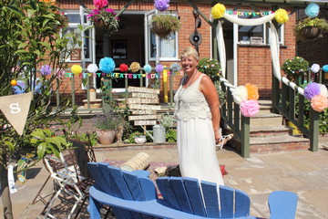An english lady wearing a beautiful dress standing in an english garden