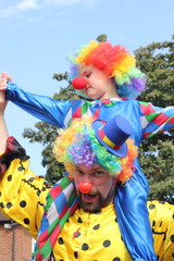 A father and son dressed as clowns on a summers day