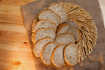 Fresh bread and straw on canvas