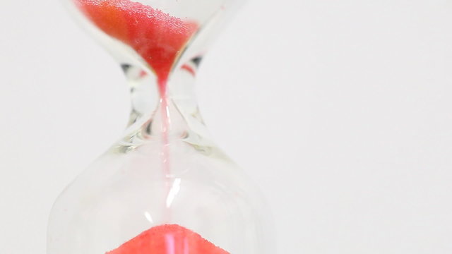 Sand falling in hourglass - passing time concept