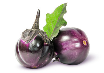 Two round ripe eggplant with green leaf
