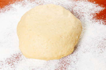 Ball of raw dough and flour