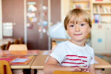 Indoor portrait of a cute little boy in a classroom