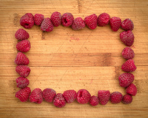 Ripe sweet raspberries on wood