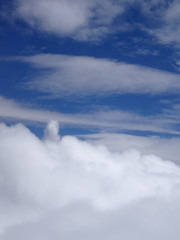 Naklejka na ściany i meble Fluffy Clouds above and below in a blue sky