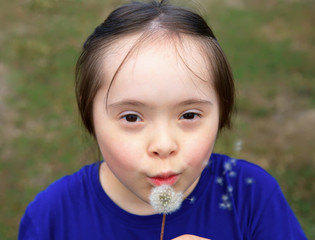 Little girl blowing dandelion