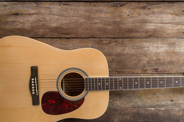 Fototapeta premium Top view of guitar on dark wood floor texture in darken tone