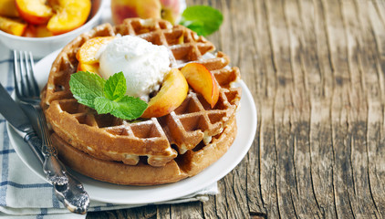 Belgian waffles with ice cream and fresh peaches