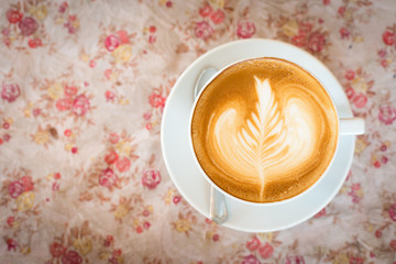 Cup of art latte or cappuccino coffee with retro filter effect a
