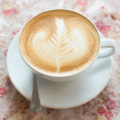 Cup of art latte or cappuccino coffee with retro filter effect a