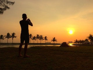 silhouette photographer taking photos during sunset