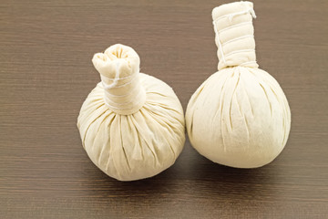 Spa herbal compressing ball on black wooden background
