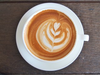 Latte Coffee art "Tulip" on the wooden desk.