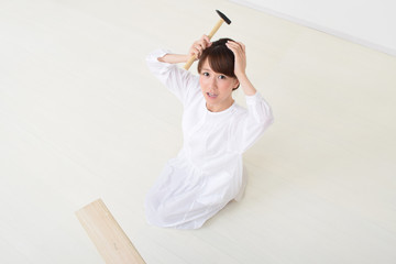 金づちを持って困る女性