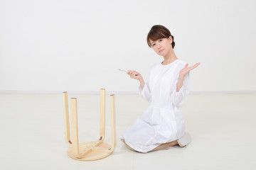 スパナで椅子を組み立てる女性