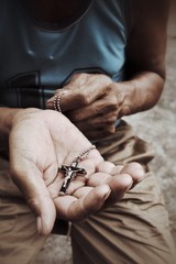 Senior man hands praying with cross