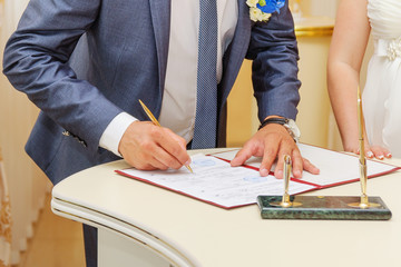 Groom signing marriage license