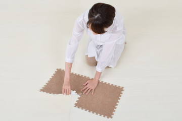 ジョイントマットを設置する女性