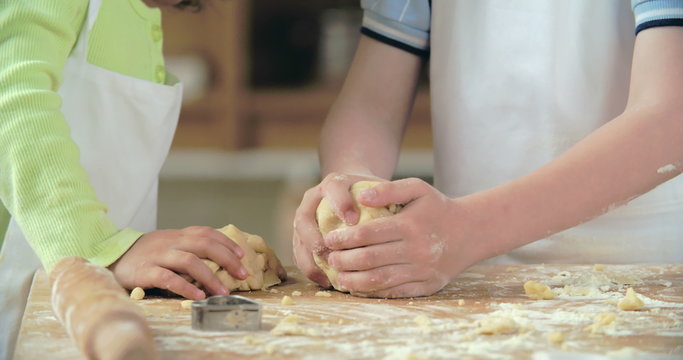 Little hands of kids kneading shortbread dough 