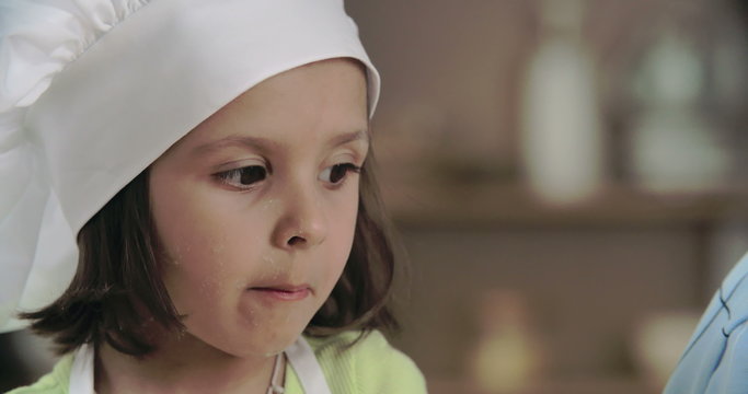 Cute preschoolers tasting sprinkles during baking class 